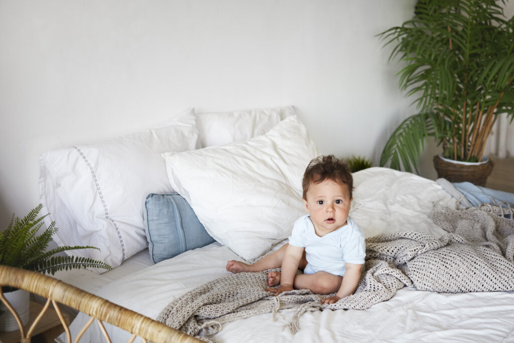 baby playing around the peekaboo pillow